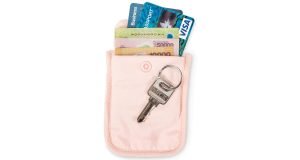 Peach colored Pacsafe Coversafe S25 Anti-Theft Secret Bra Pouch with key, cash and cards.