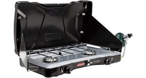 Black Coleman Triton 2 Burner with wind shielding.